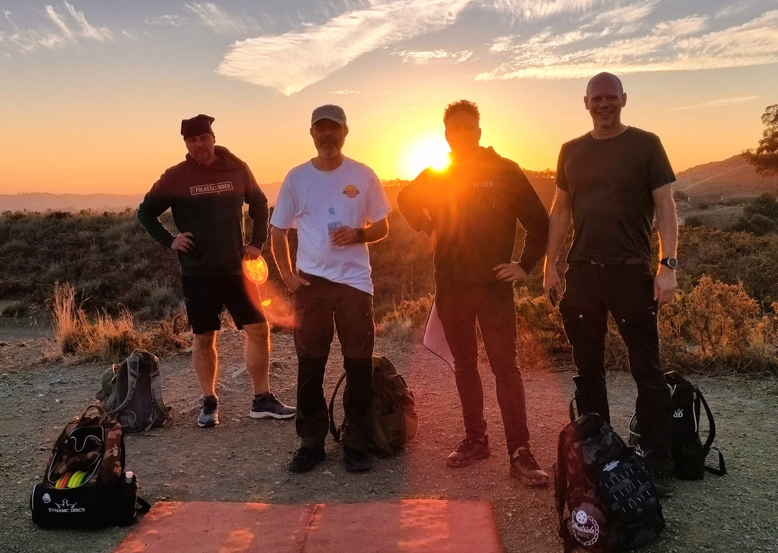 Fyra discgolfspelare i solnedgången på banan i Mijas
