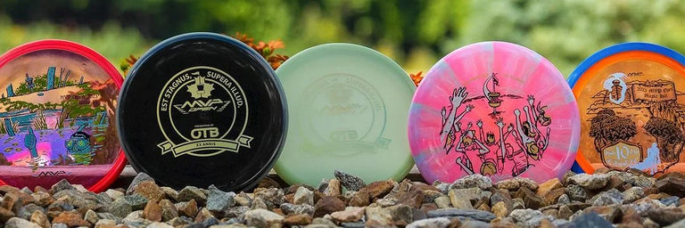 5 forskellige MVP Network disc golf discs der står på npgle småsten